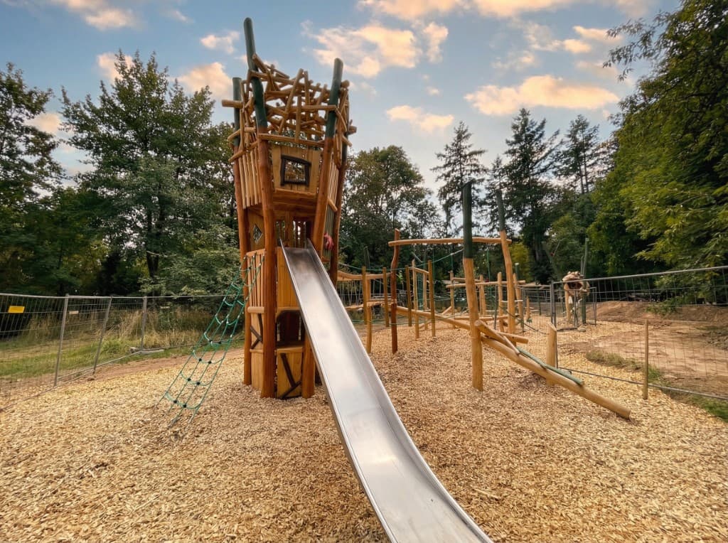 Imposanter Holzturm mit kunstvoller Dachkonstruktion und angeschlossenem Kletterparcours