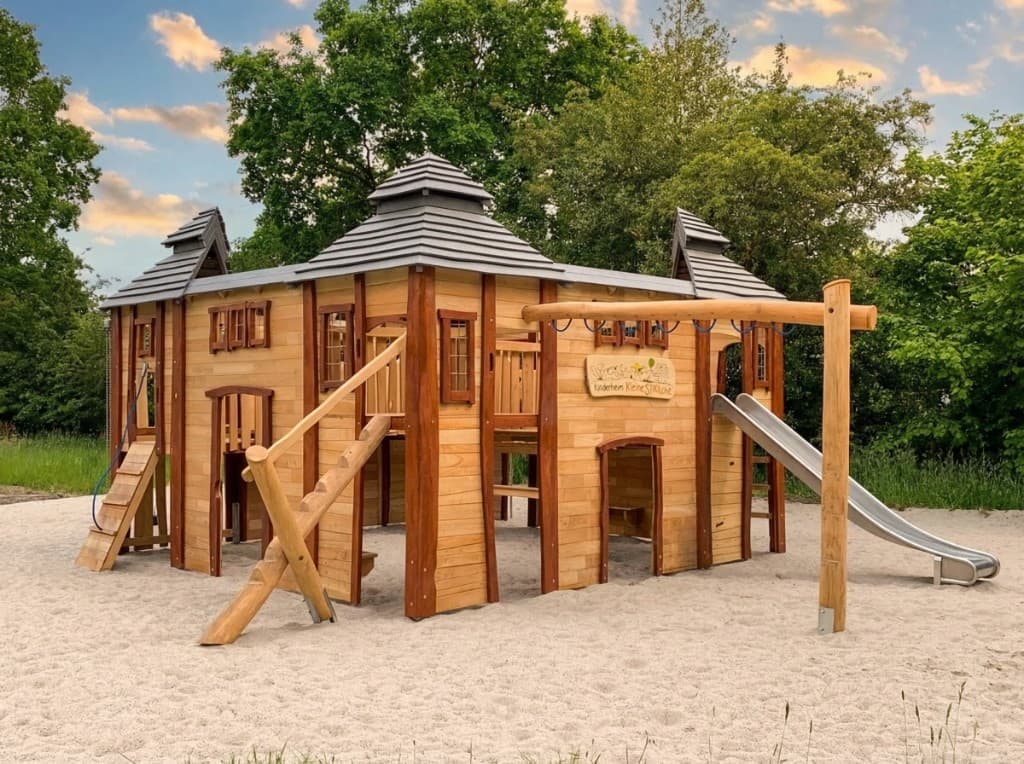 Großzügiges Spielhaus mit mehreren Türmen und Dächern für eine Kindertagesstätte